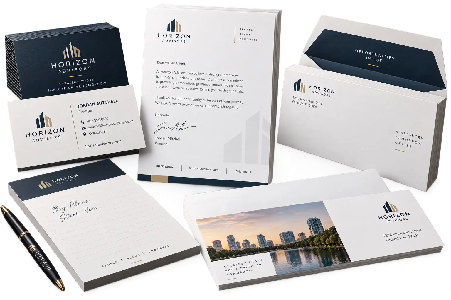 Business cards, letterhead, envelopes, and notepads arranged on a studio surface.